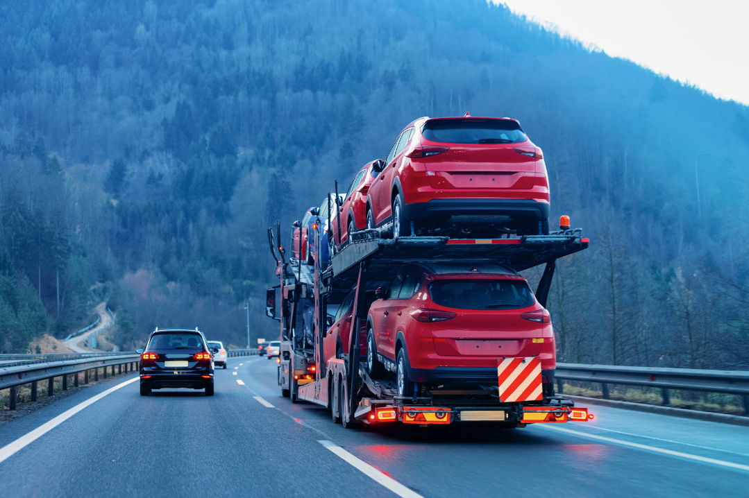 auto transport carrying several vehicles on highway